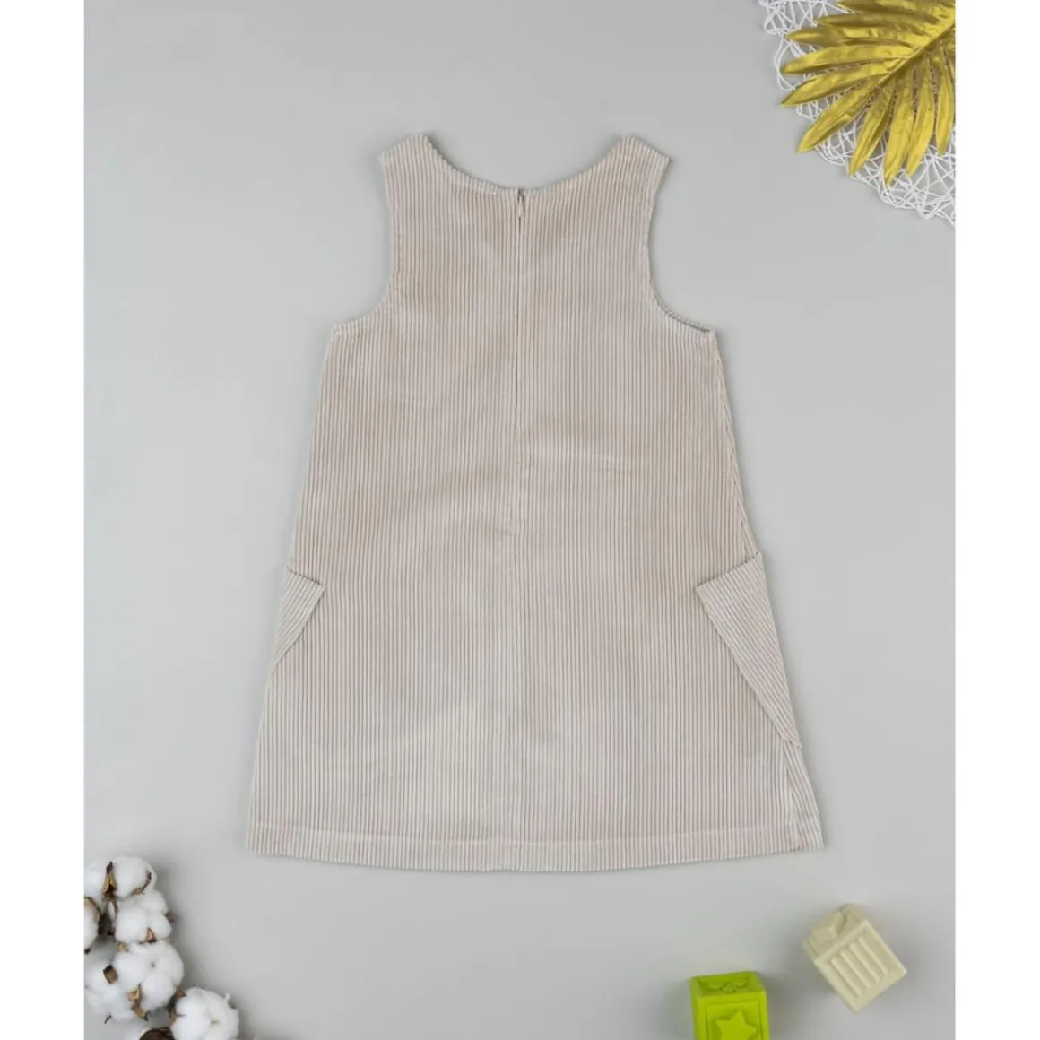 Peto de pana beige con detalle floral para niña