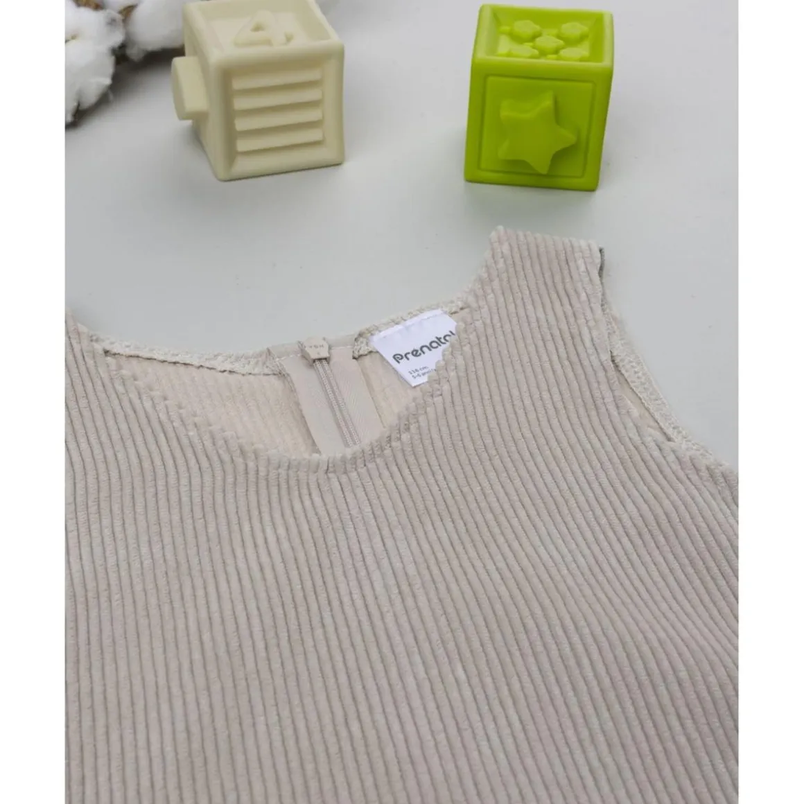 Peto de pana beige con detalle floral para niña