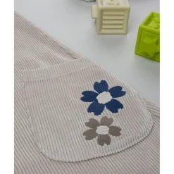 Peto de pana beige con detalle floral para niña